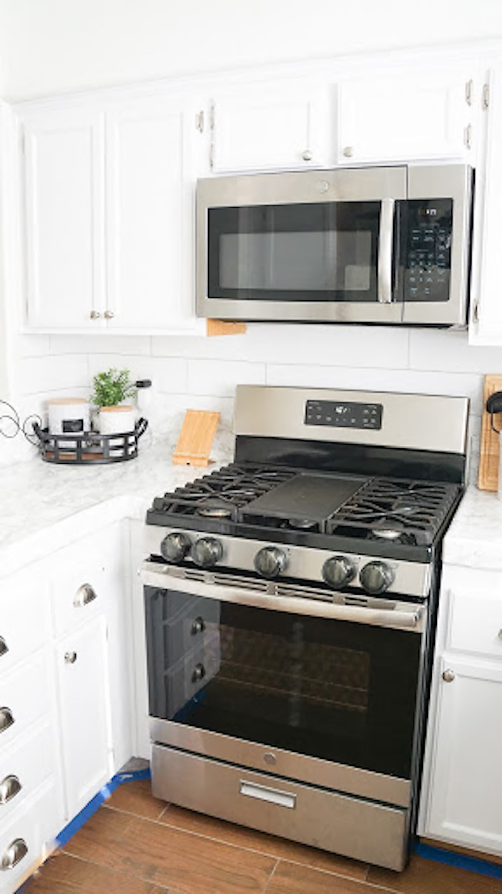 A kitchen backsplash is updated with a white subway tile looking removable wallpaper.