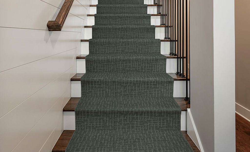 A green stair runner installed on a flight of stairs.