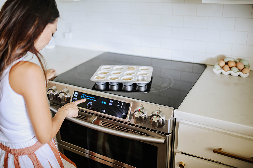 A woman touching the control panel on a Samsung double oven.