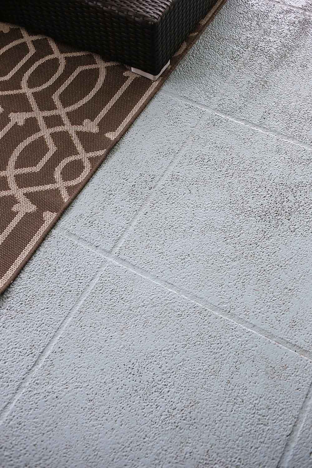 A brown outdoor rug on a concrete patio floor. A brown outdoor rug on a concrete patio floor.