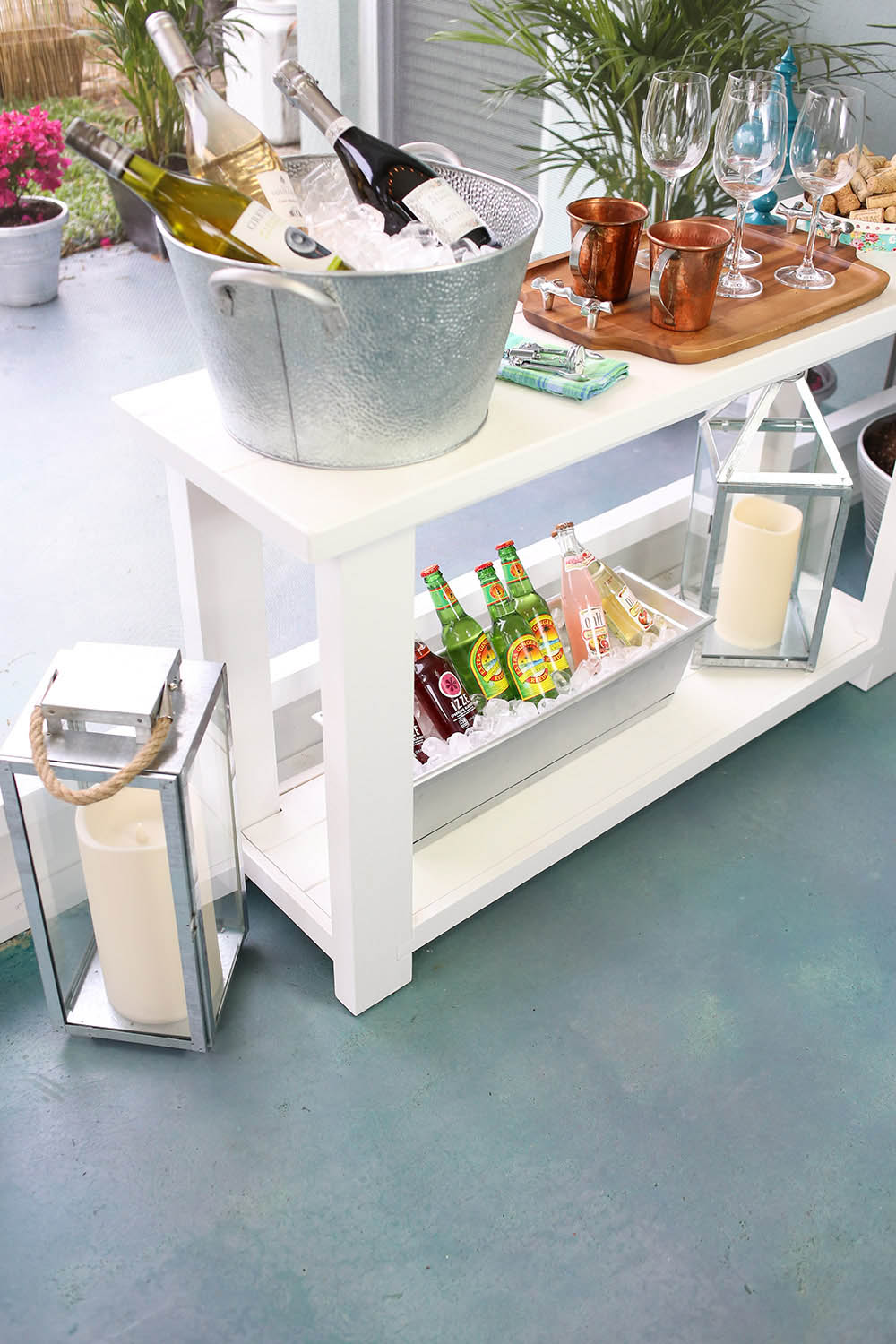 A white piece of furniture decorated with drinks, snacks, and lanterns. A white piece of furniture decorated with drinks, snacks, and lanterns.