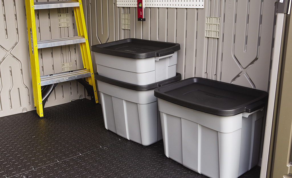 Three storage bins inside a shed.