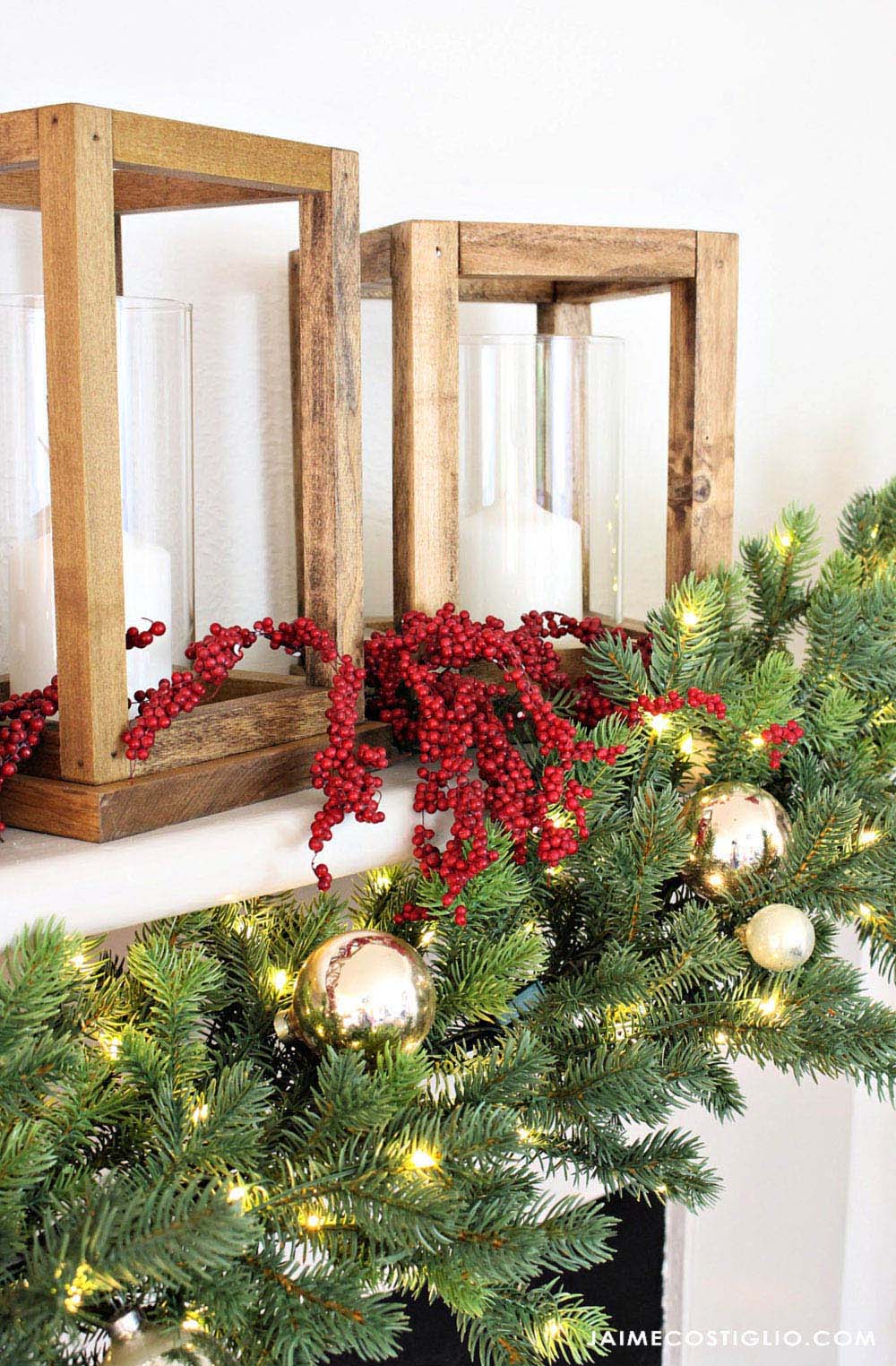 Holiday garland on a mantel with lights, ornaments and candles. 