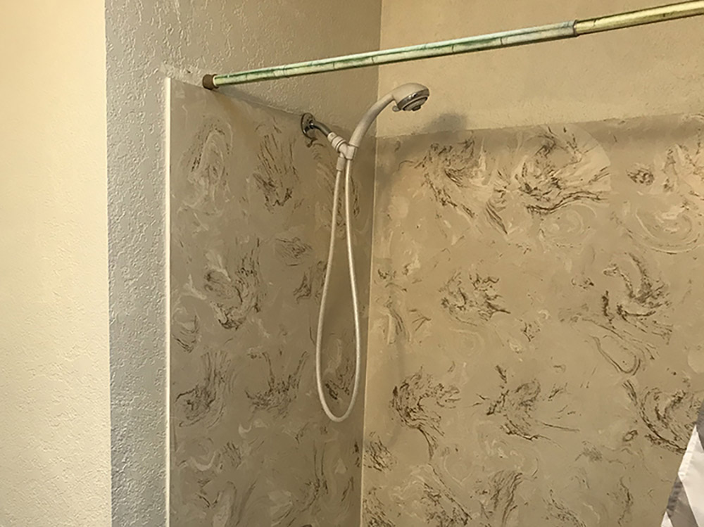 A shower head mounted to the shower wall.