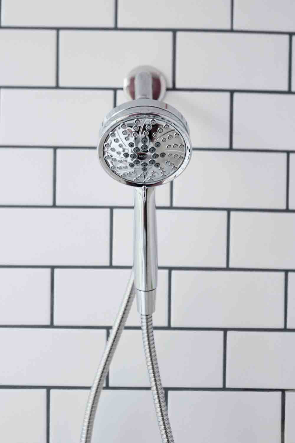 A Moen Magnetix shower head mounted on a tile wall.