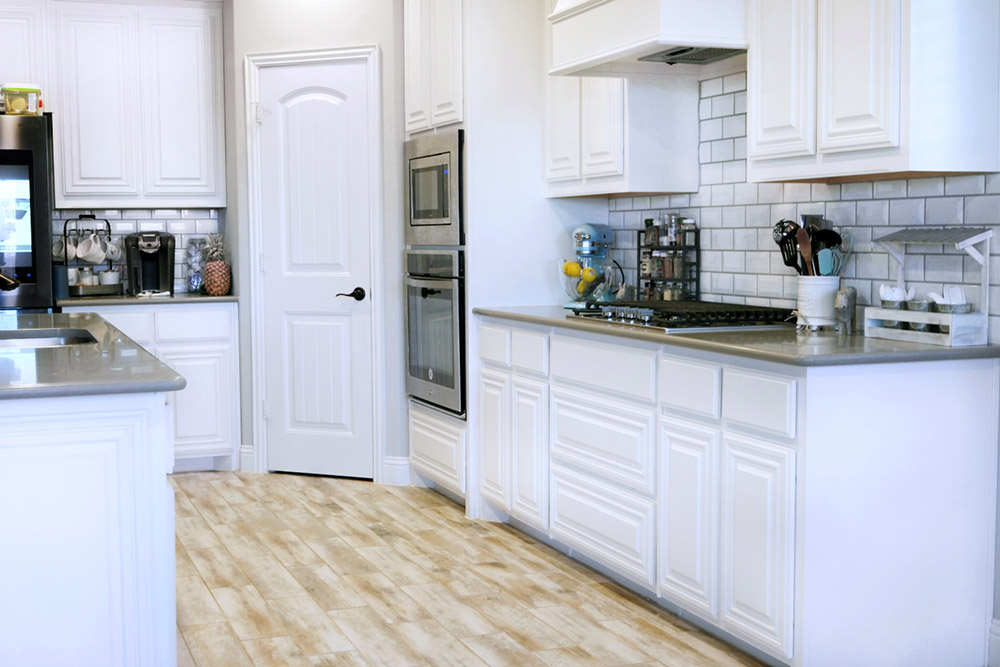 Kitchen with all white cabinets and drawers. 