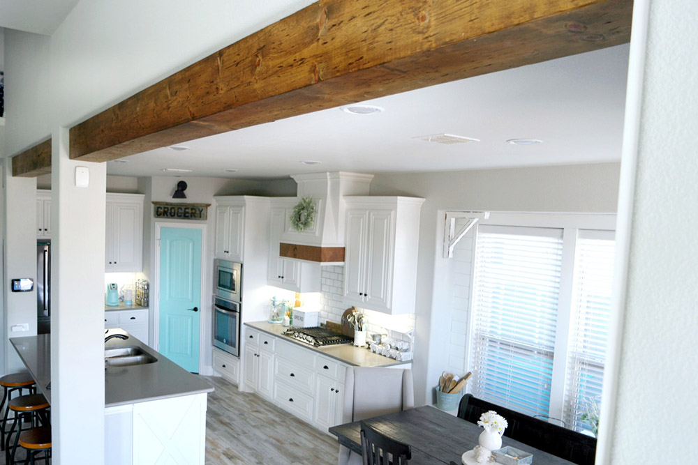 An open farmhouse style kitchen with wooden beams.