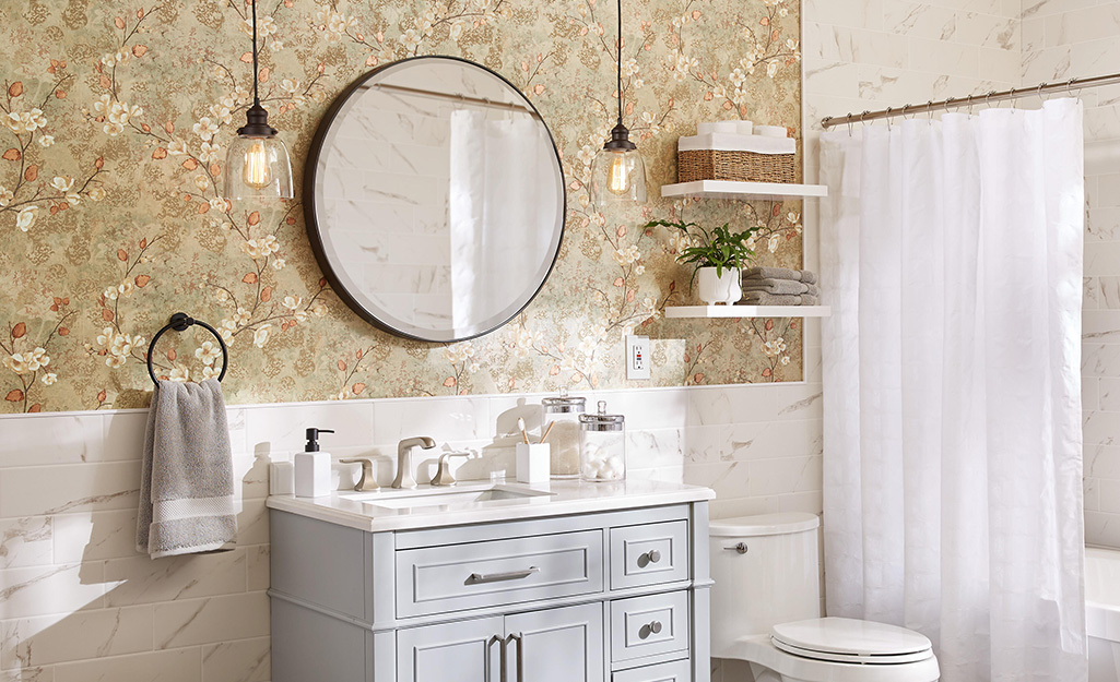 Oversized round mirror installed over a single vanity.