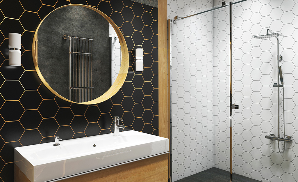 Narrow white vanity and round mirror against a honeycomb wall.