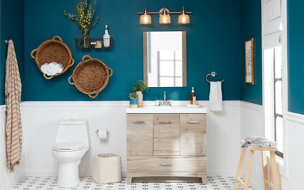 A single vanity and toilet in a blue and white bathroom.