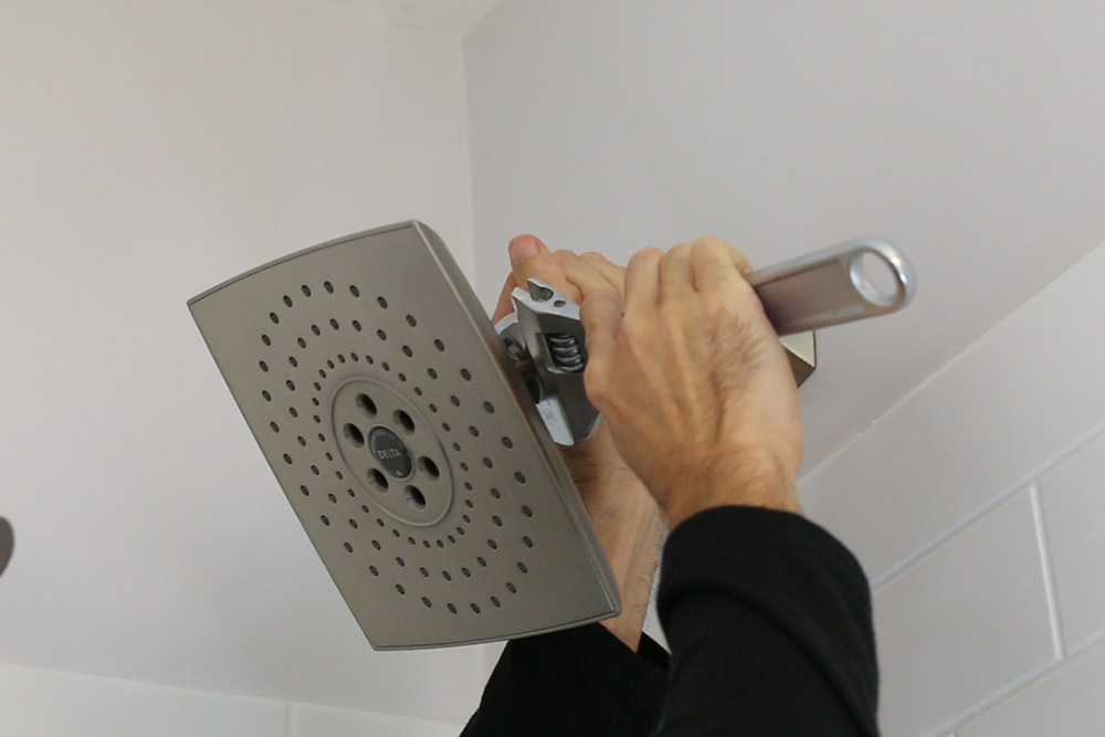 A person installing a shower head. A person installing a shower head.