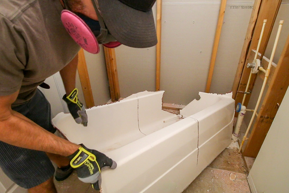 A person removing a tub. A person removing a tub.