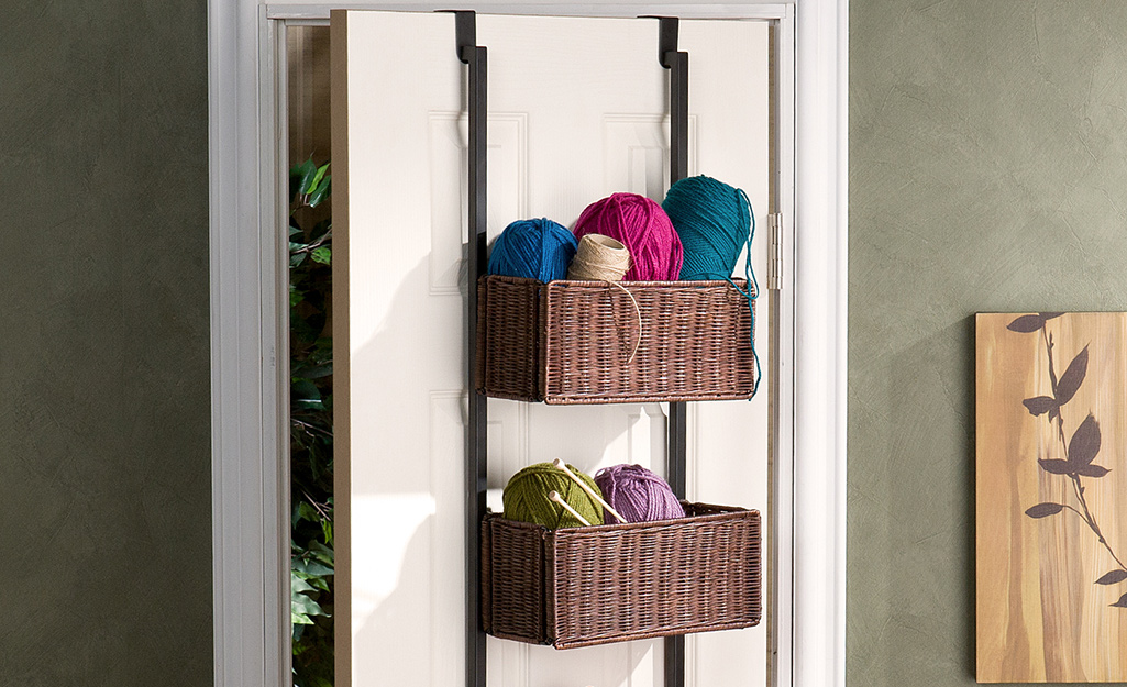 A closet door with over the door storage holding yarn and knitting needles.