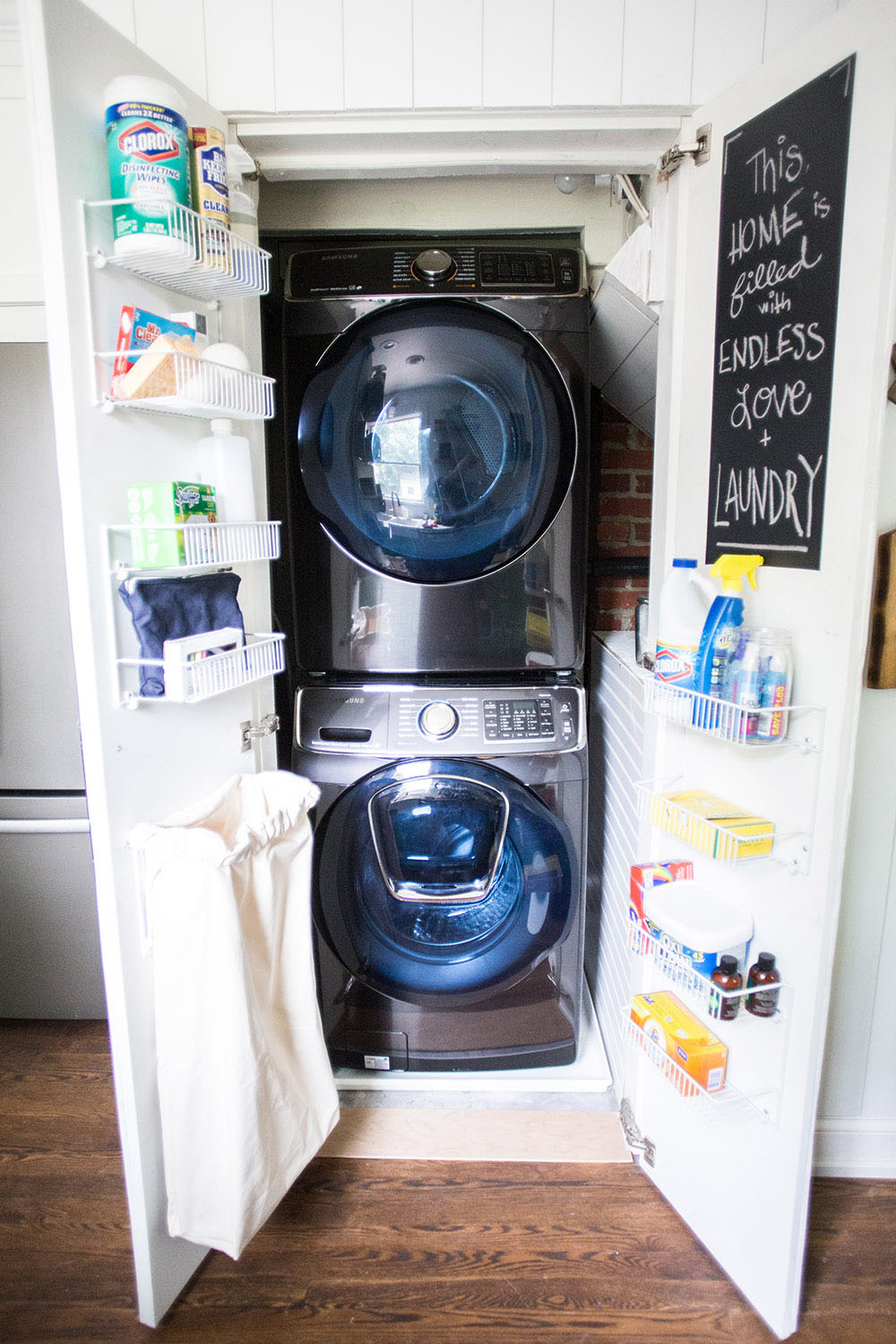 A closet with a washing machine, a dryer, and shelves on the doors.