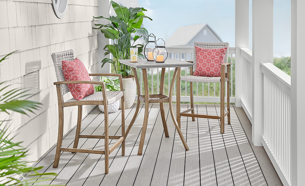 a small patio featuring a wooden 3-piece bistro set