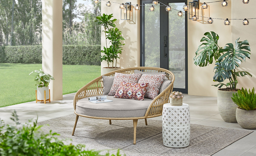 A small patio with outdoor plants and string lights.