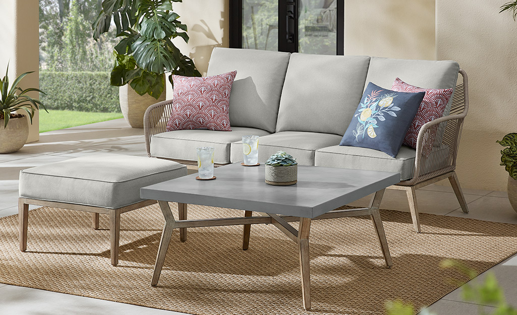 A small patio featuring a loveseat and coffee table.