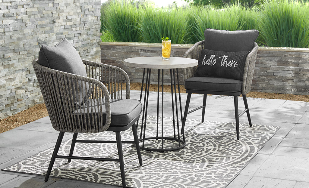 a small patio featuring a wooden 3 piece bistro set