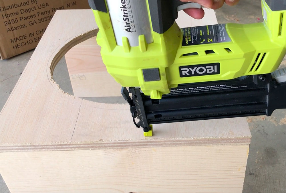 A person attaching a plywood top and legs. A person attaching a plywood top and legs.