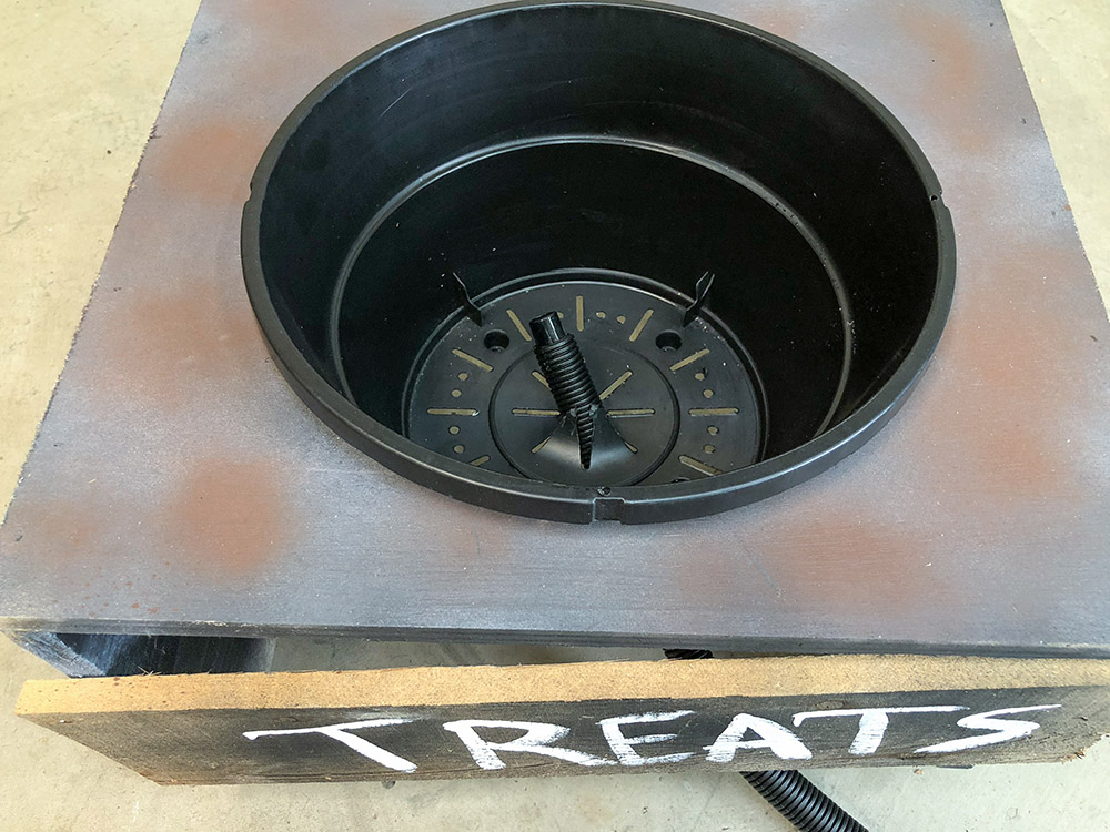 A hanging basket sits inside a DIY treat holder.