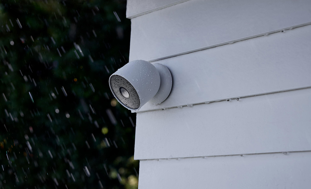 A home security camera attached to the outside a house
