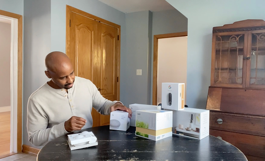 Man sitting at table with smart home products.