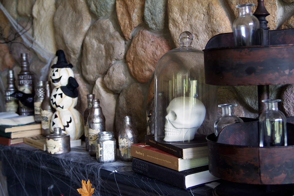 The side view of a mantel decorated with potion bottles for Halloween.