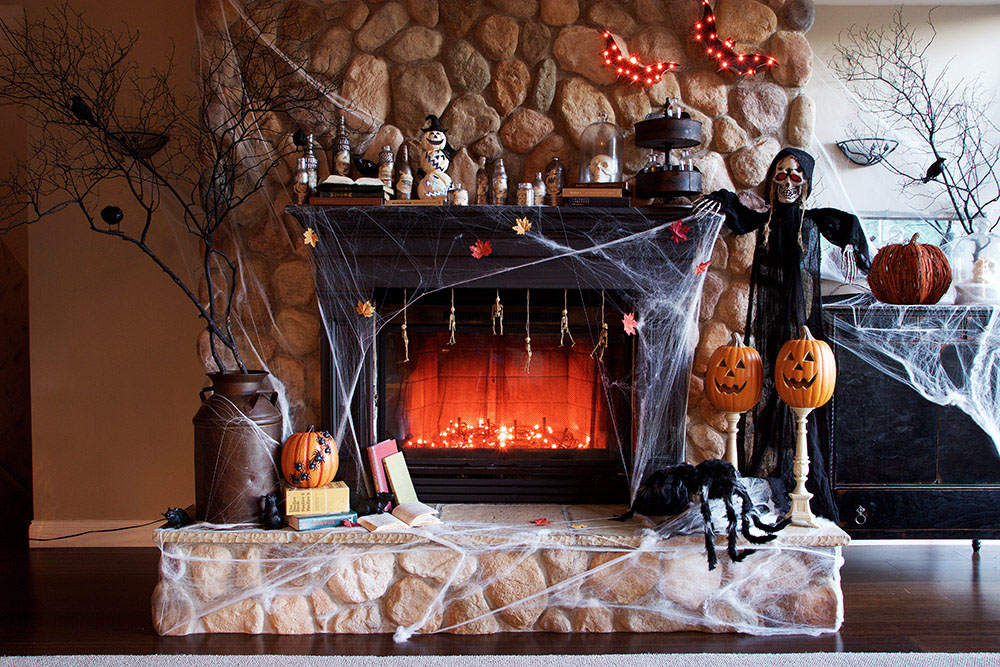 A fireplace with spooky tree branches on either side.