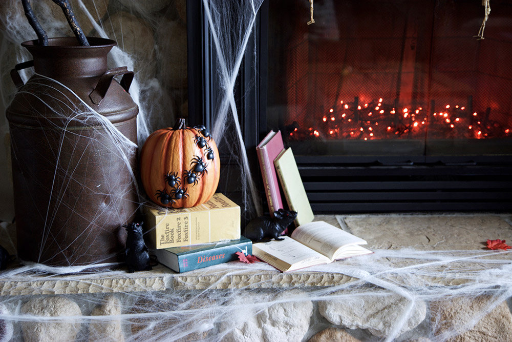 A fireplace filled with orange string lights for Halloween.