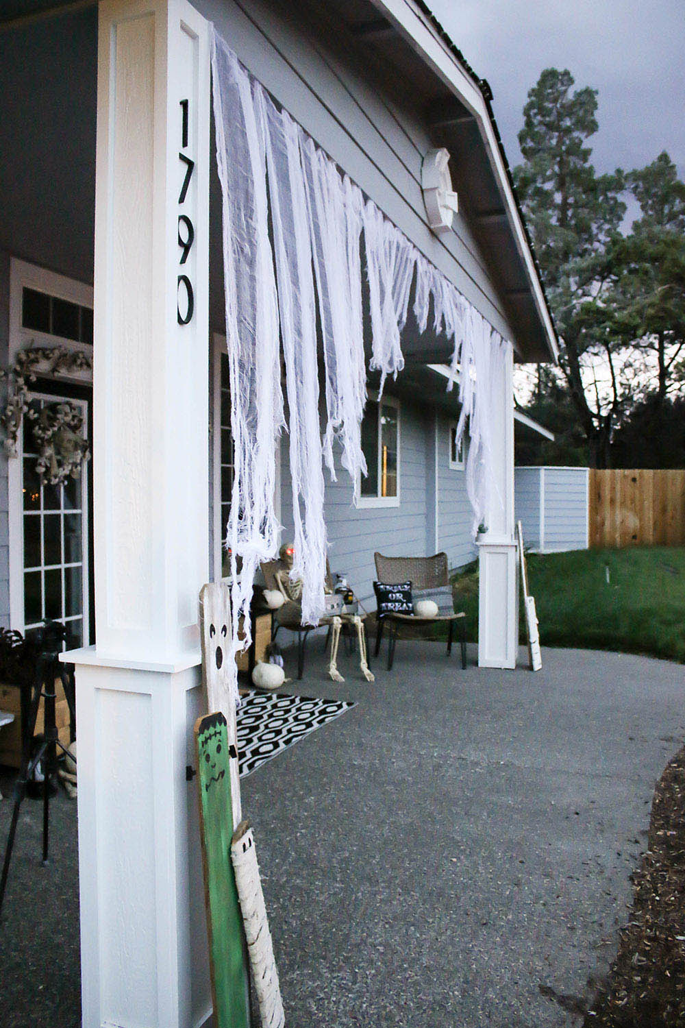 A front porch decorated with ripped curtains made from cheesecloth.
