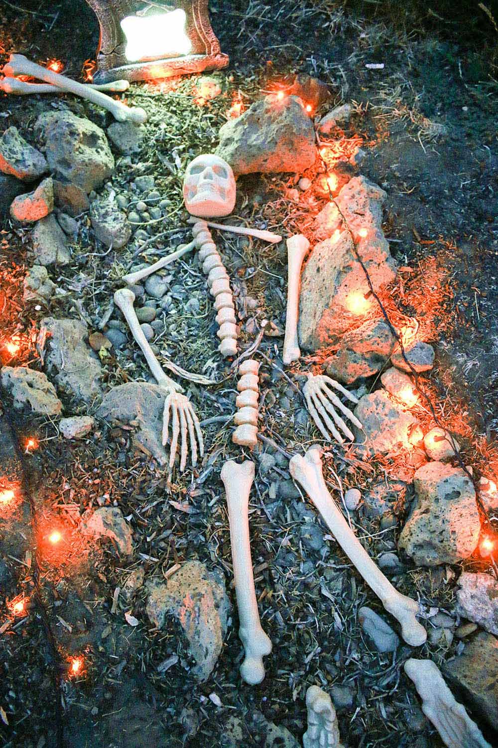 A grave with skeleton bones surrounded by orange lights.