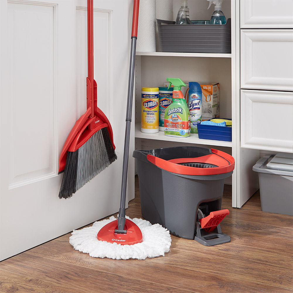 Broom, mop and other cleaning supplies in an open closet.