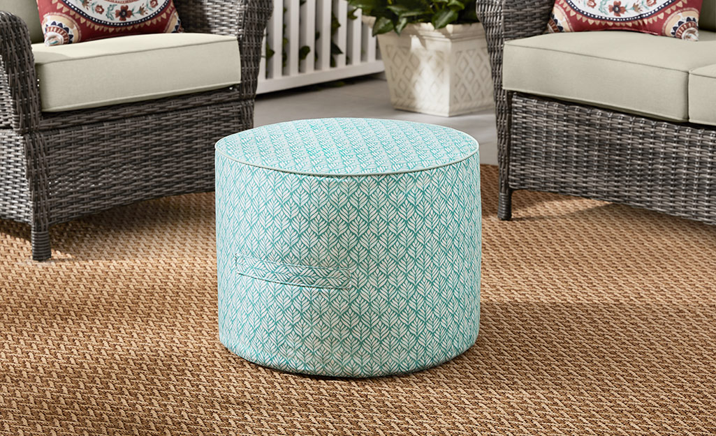 A light teal and white patterned outdoor pouf. A light teal and white patterned outdoor pouf.