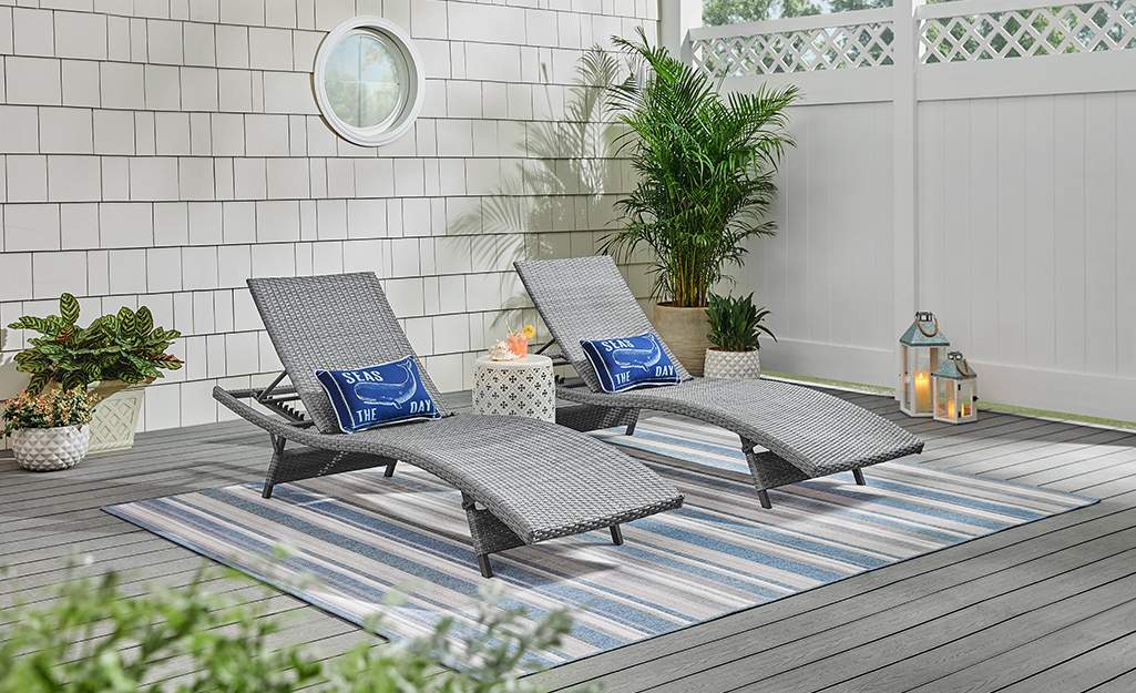 Gray outdoor patio set with gray and blue striped rug. Gray outdoor patio set with gray and blue striped rug.