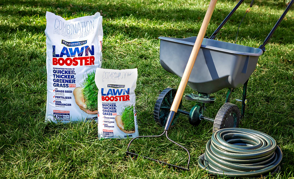 Bags of fertilizer, a spreader, hose and garden tools. 
