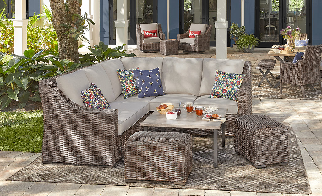 A sofa, table and wicker benches on a patio.
