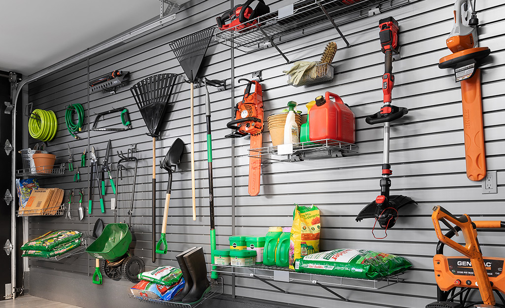 A garage with garden tools and outdoor power equipment