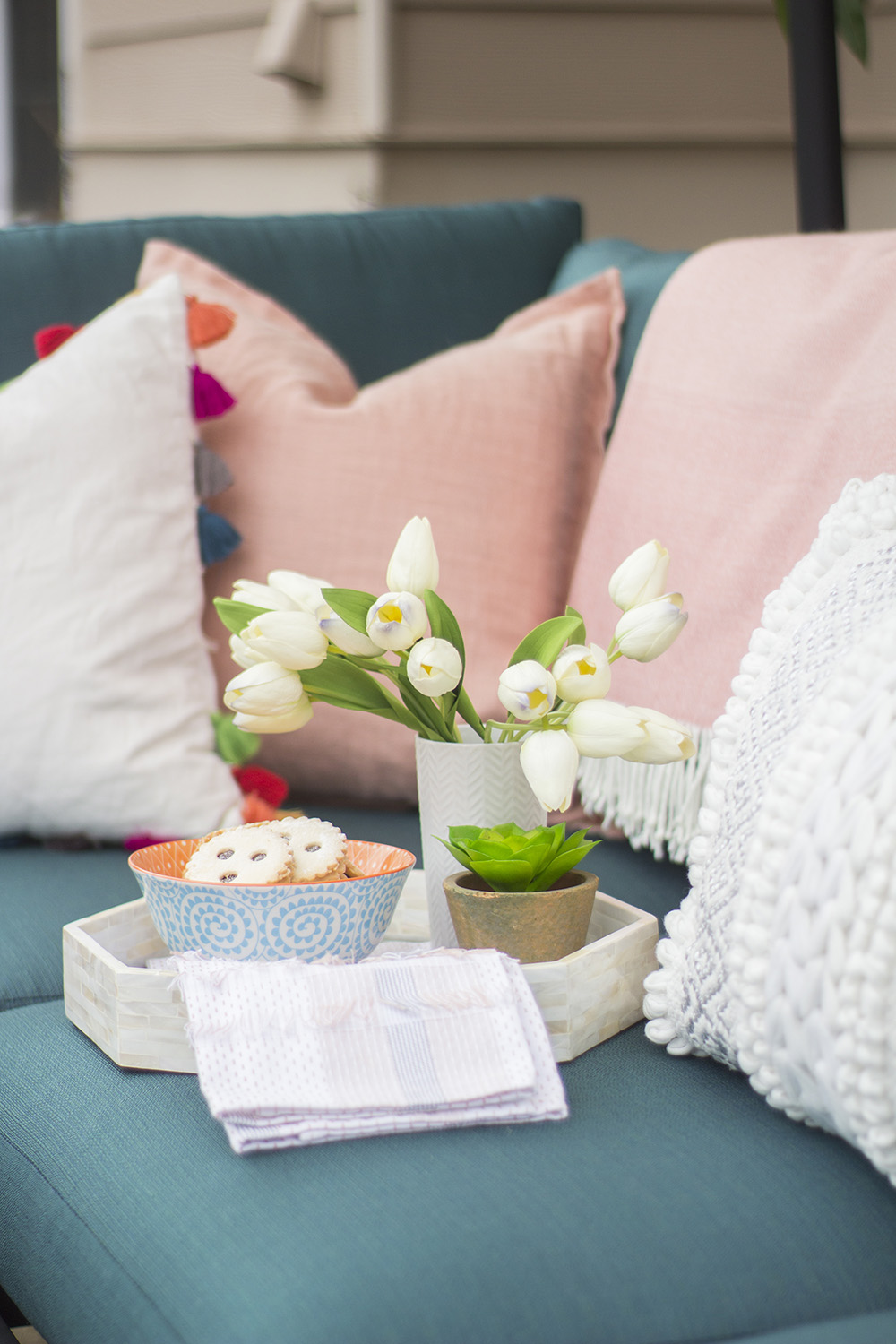 The corner of an outdoor sectional decorated with pink and white pillows. The corner of an outdoor sectional decorated with pink and white pillows.