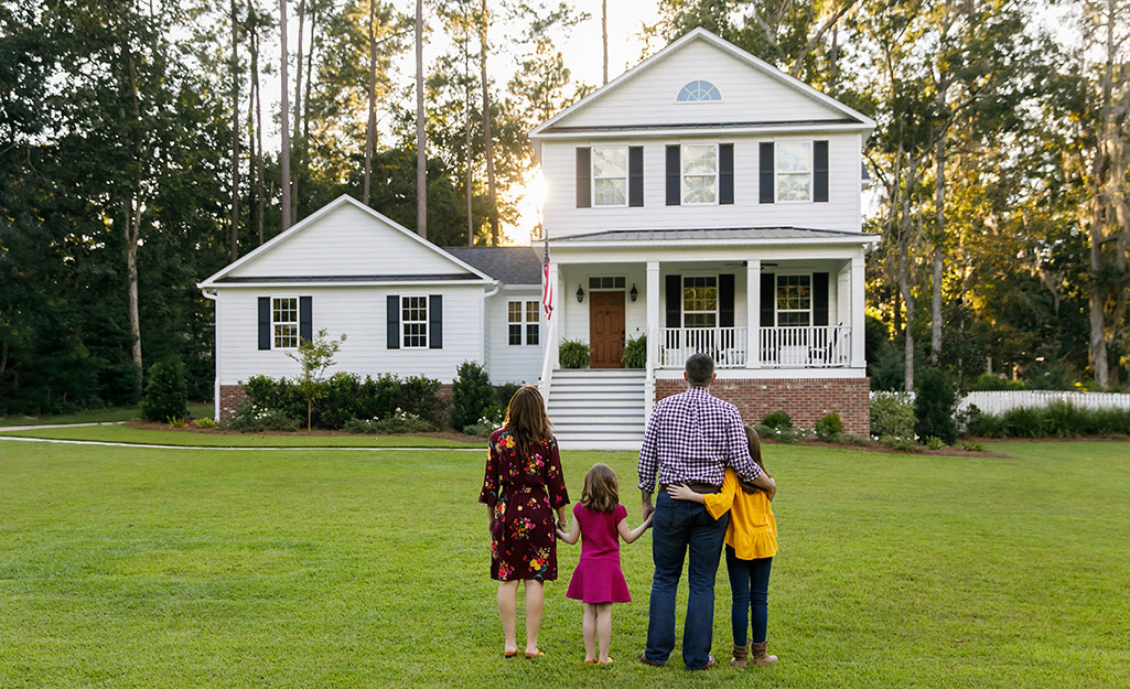 A family standing outside a home.