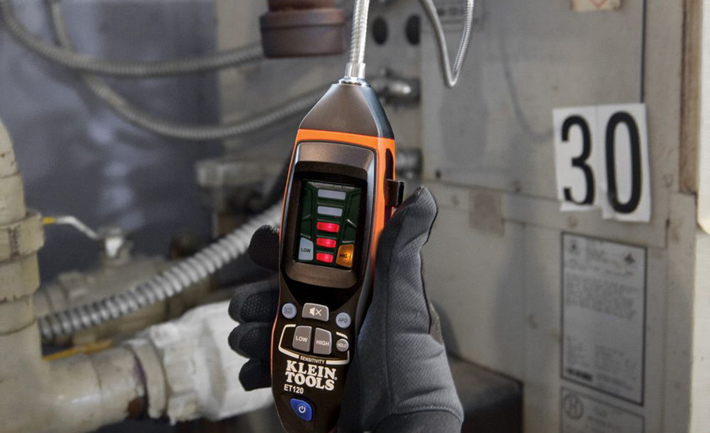 A person using a gas detector. A person using a gas detector.