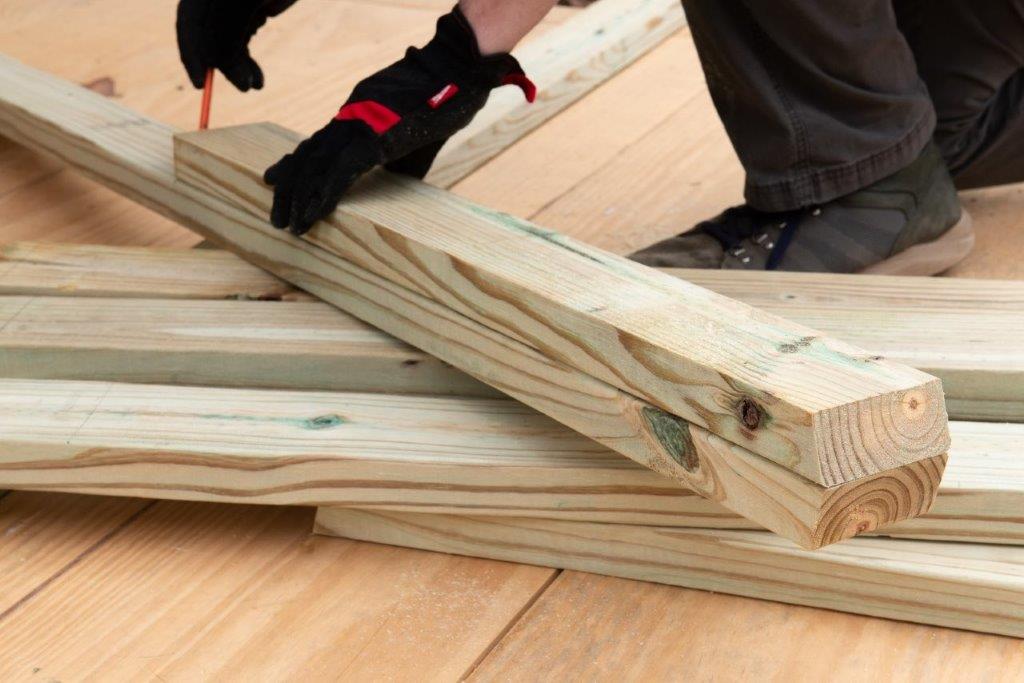 A Pro measures a board before cutting it into a sawhorse leg. A Pro measures a board before cutting it into a sawhorse leg.