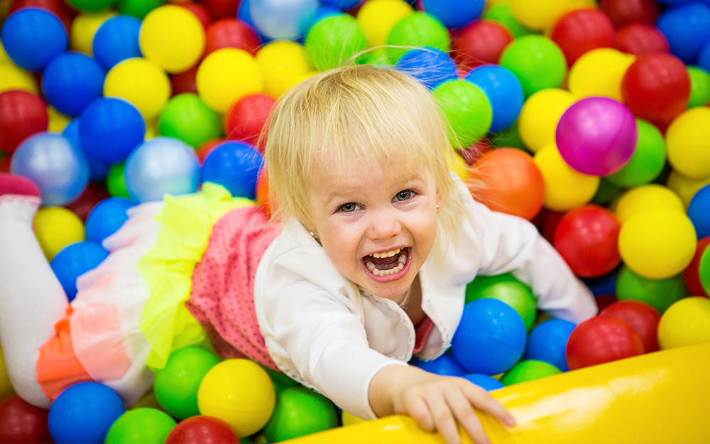 A child plays in a ballpit. A child plays in a ballpit.