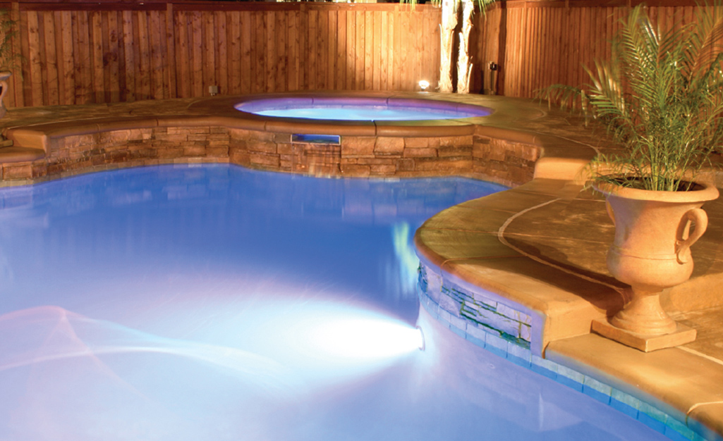 A salt water swimming pool lit up at night.