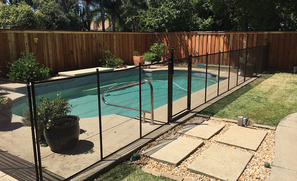An outdoor pool surrounded by a pool fence.