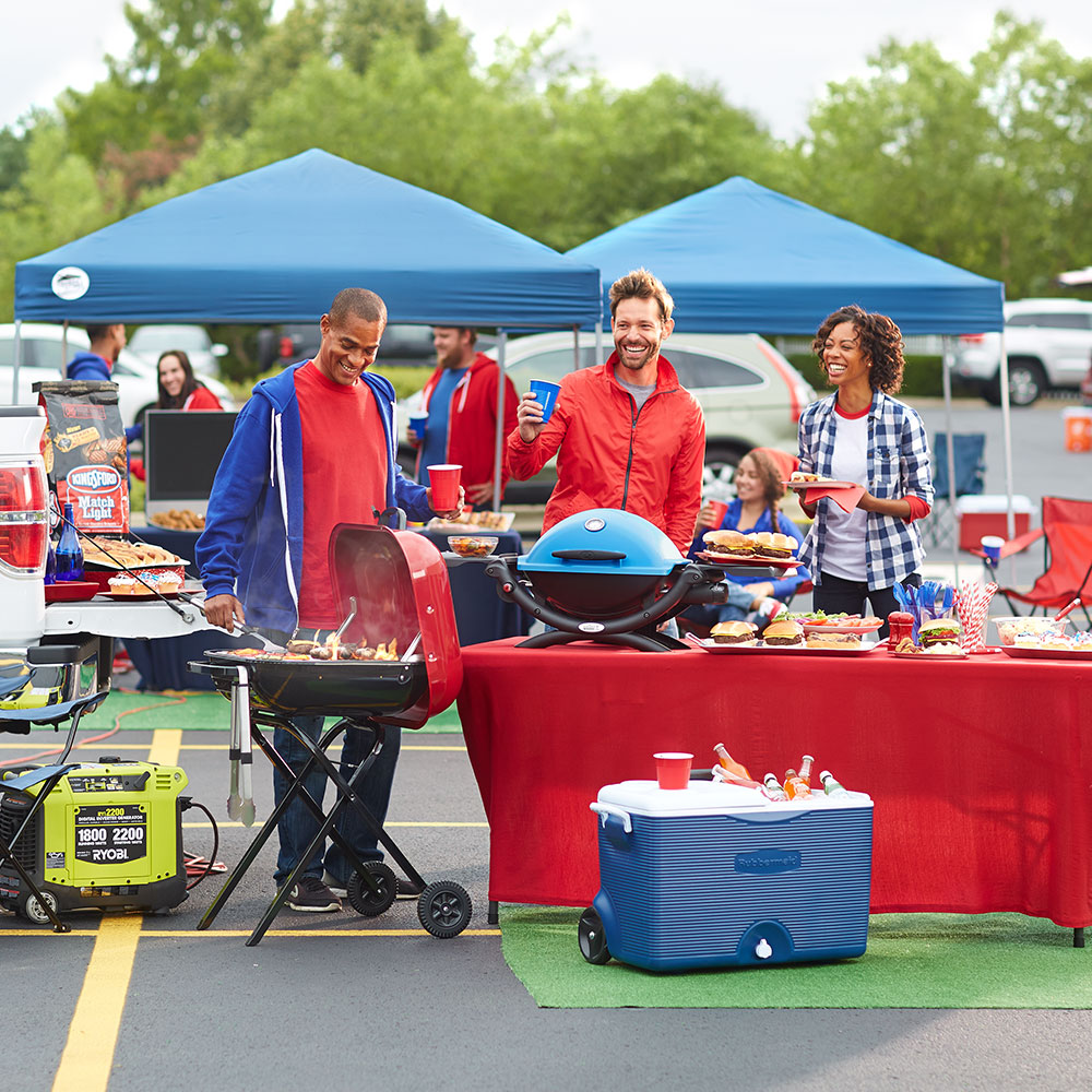 Friends tailgate together outside a football game. 