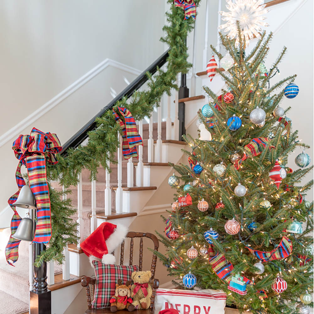 A home decorated for Christmas with garland, bows, and a Christmas tree.