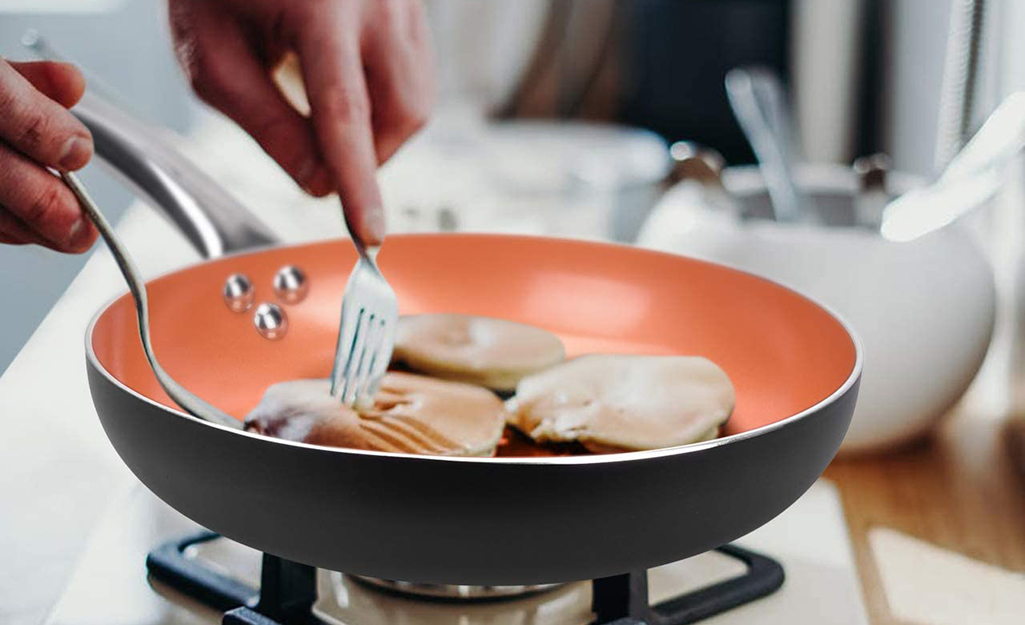 A person using a non-stick frying pan.