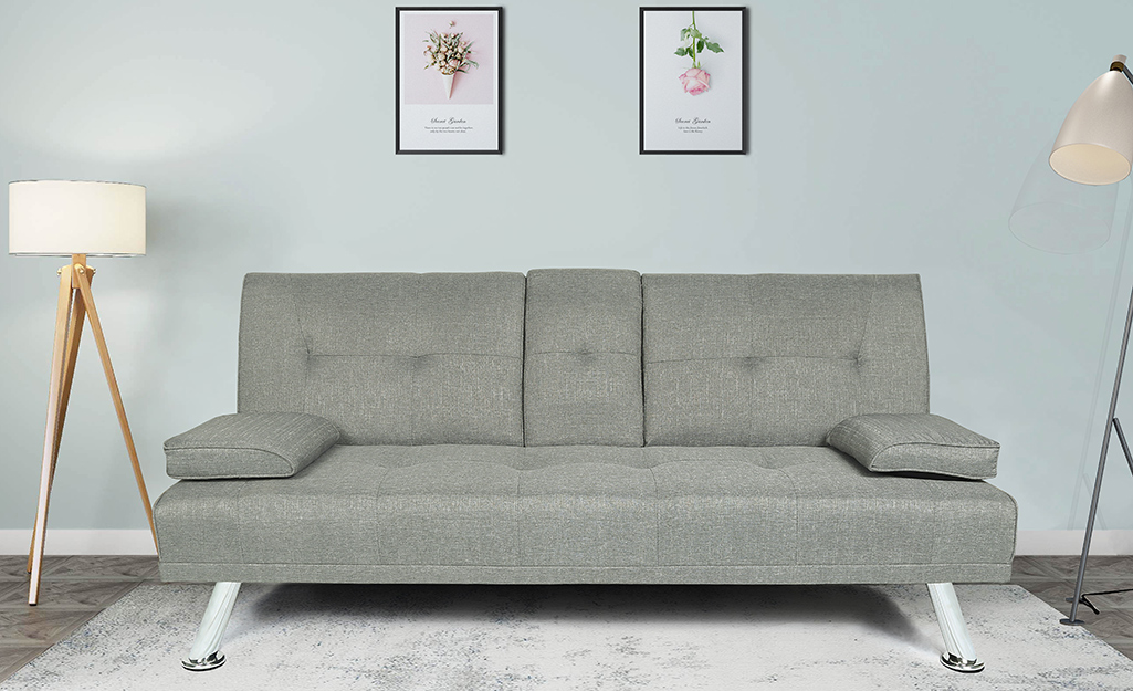 A grey futon with white metal frame in a living area