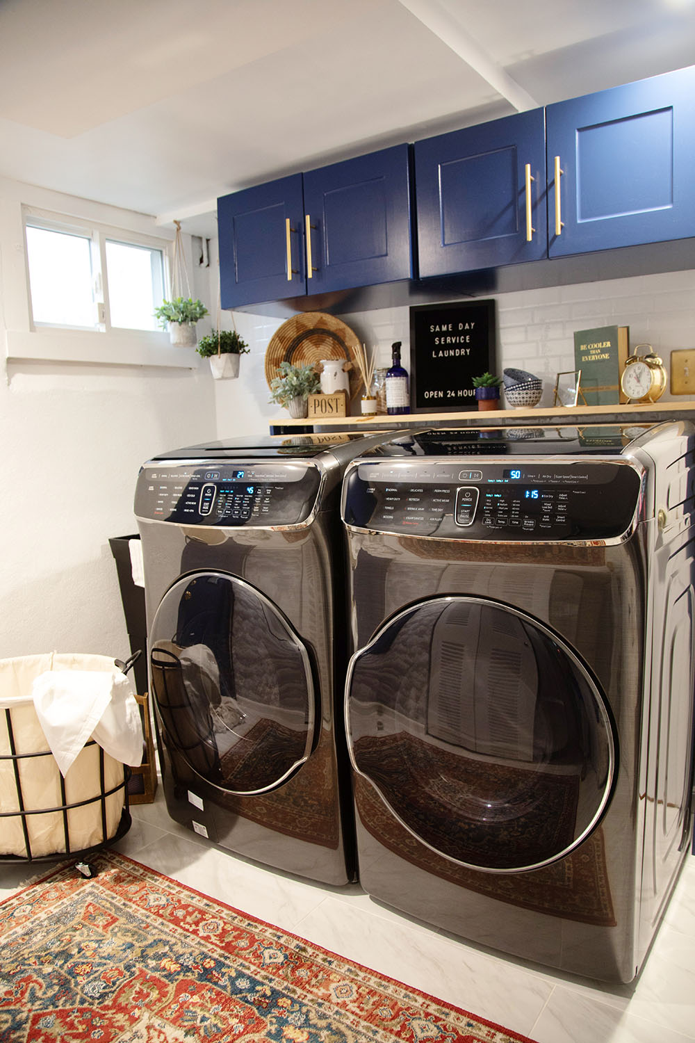 A Samsung FlexWash and FlexDry in a laundry room with blue upper cabinets.