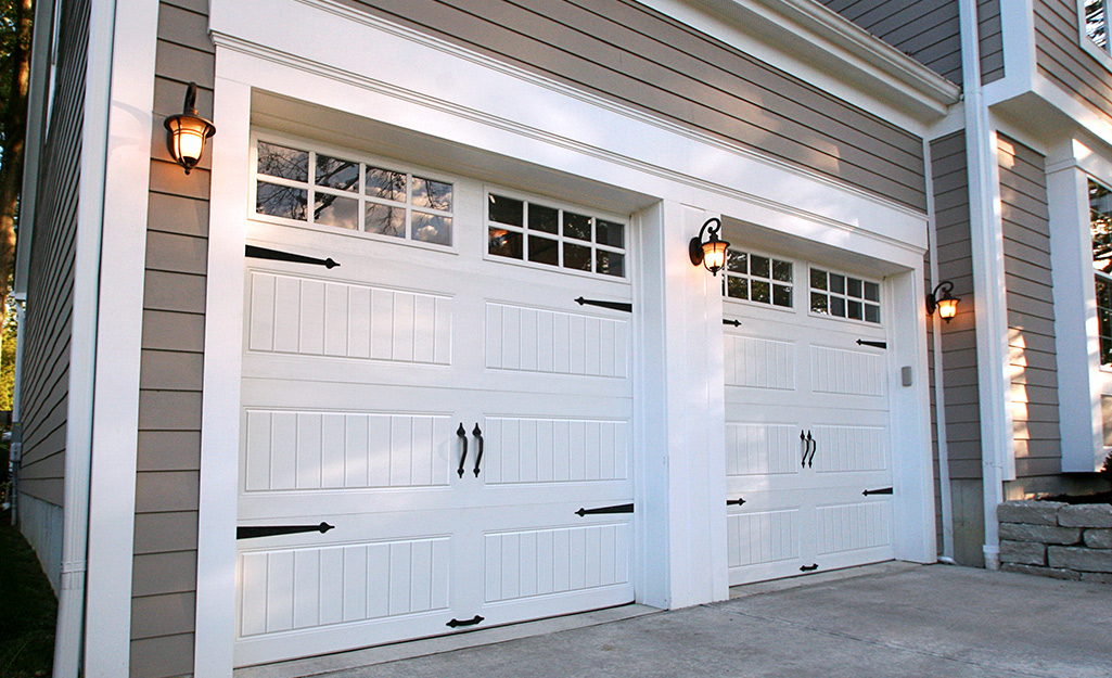 Three exterior lights placed evenly on a double-car garage.